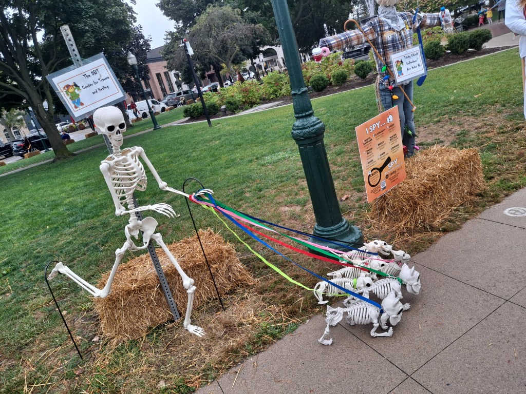 A human skeleton attempts to walk several dog skeletons.